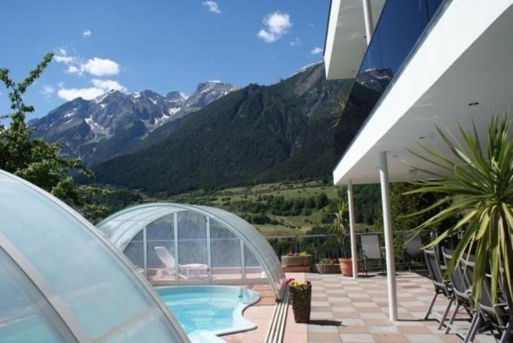 a house with a swimming pool and mountains in the background at Komfortables Ferienhaus in Landeck mit Privatem Pool in Landeck
