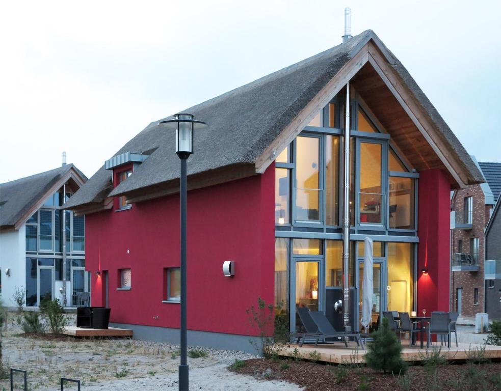 ハイリゲンハーフェンにあるOstsee - Reetdachhaus Nr 14 "DasRoteHaus" im Strand Resortの縞屋根の赤い家