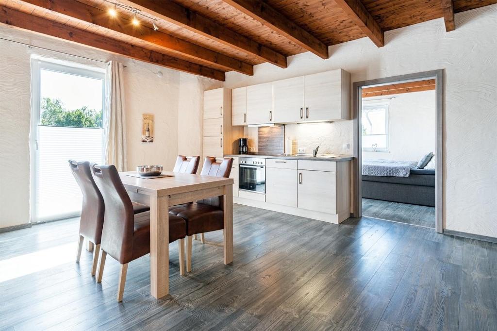 a kitchen and dining room with a table and chairs at Nr 1 Meerhusen - Barrierefrei in Aurich