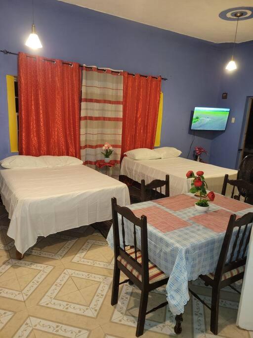 a room with two beds and two tables and a television at Country Style living in Albion