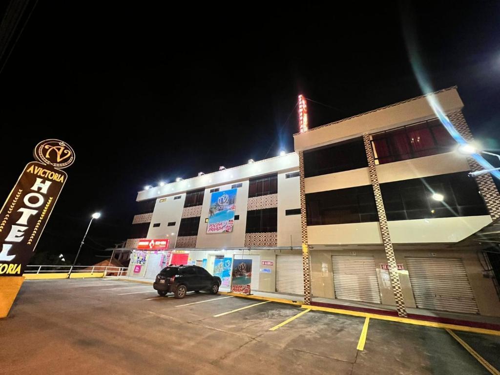 un estacionamiento frente a un edificio por la noche en HOTEL AVICTORIA en Tonsupa