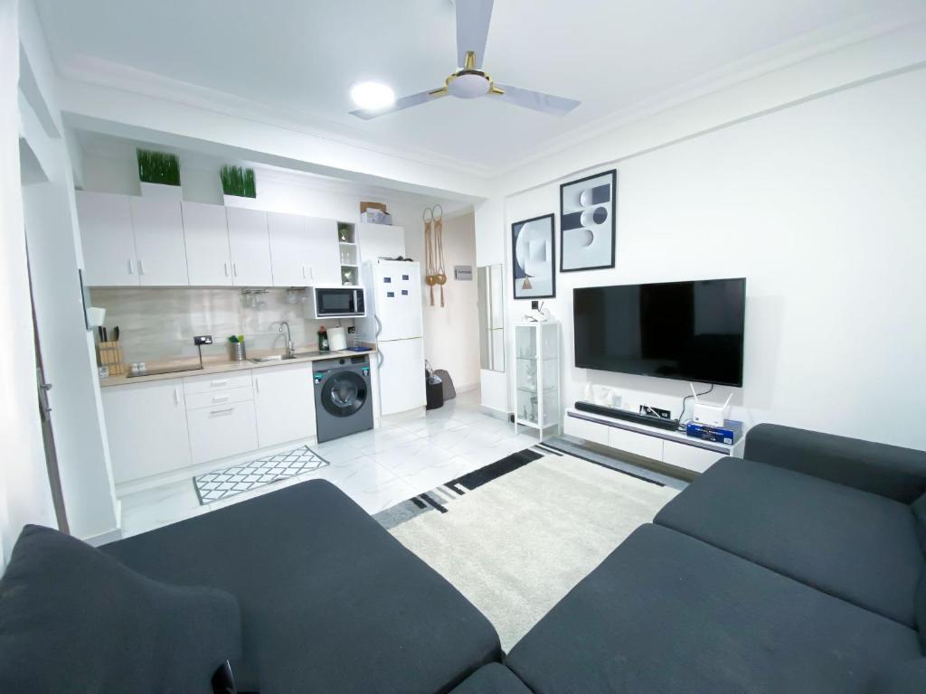uma sala de estar com um sofá e uma cozinha em Green-Hills Apartment em Kwabenya