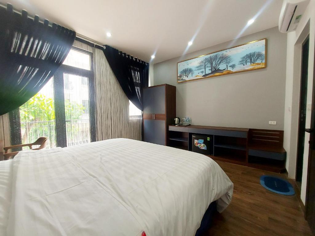 1 dormitorio con cama blanca y ventana grande en Hany Homestay - Vinhomes Ocean Park, en Hòa Bình