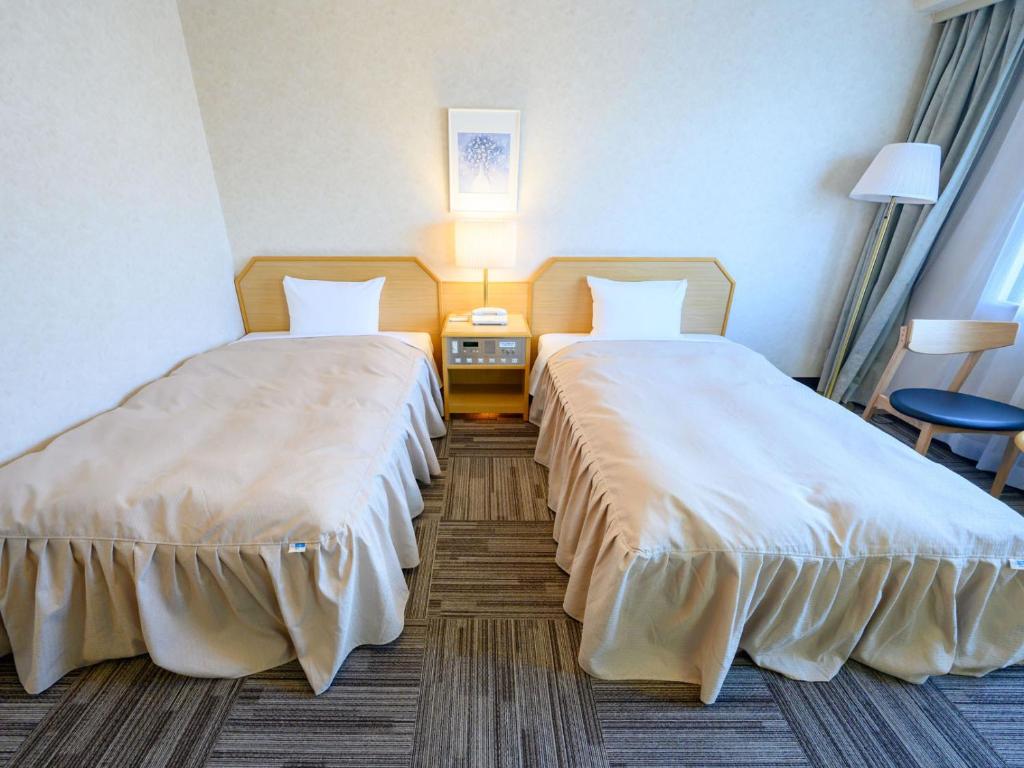 Postel nebo postele na pokoji v ubytování Iga Ueno City Hotel