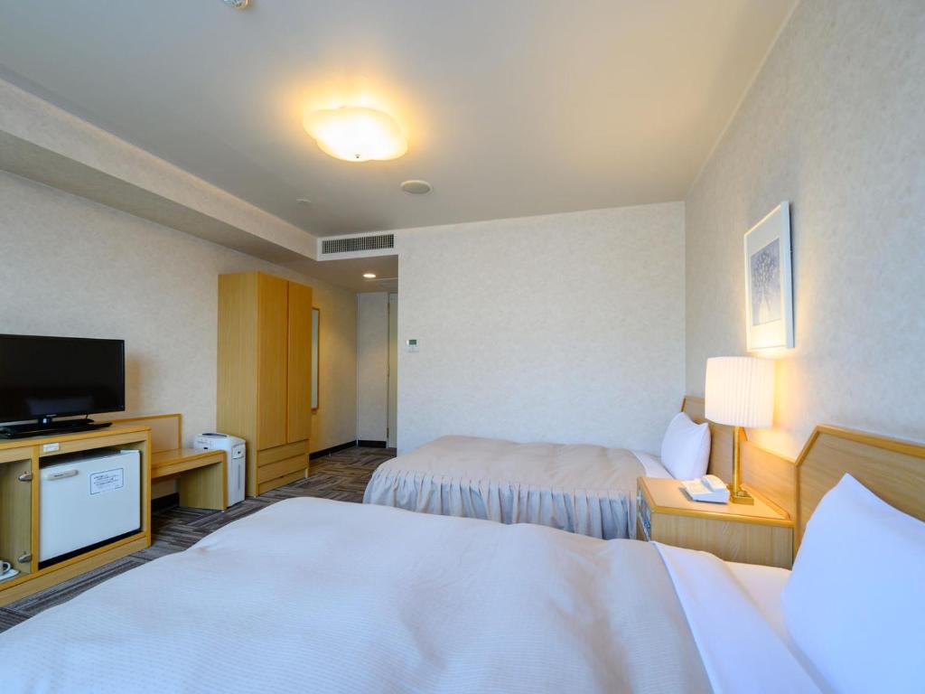 Postel nebo postele na pokoji v ubytování Iga Ueno City Hotel