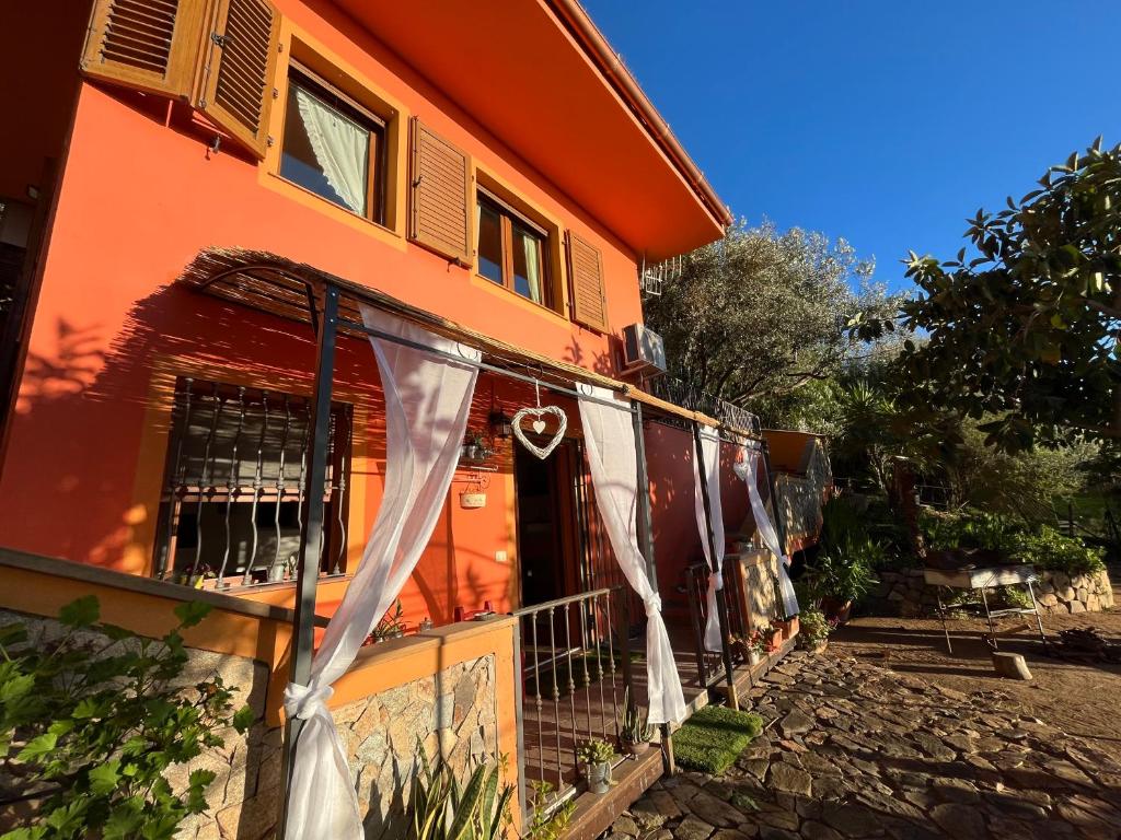 een huis met een wit gordijn bij Relax House & Garden in Santa Luria