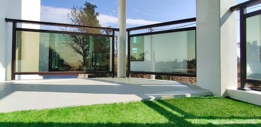 an empty house with large windows and green grass at 嚨口十二之一民宿Longcall 12-1 in Jinning