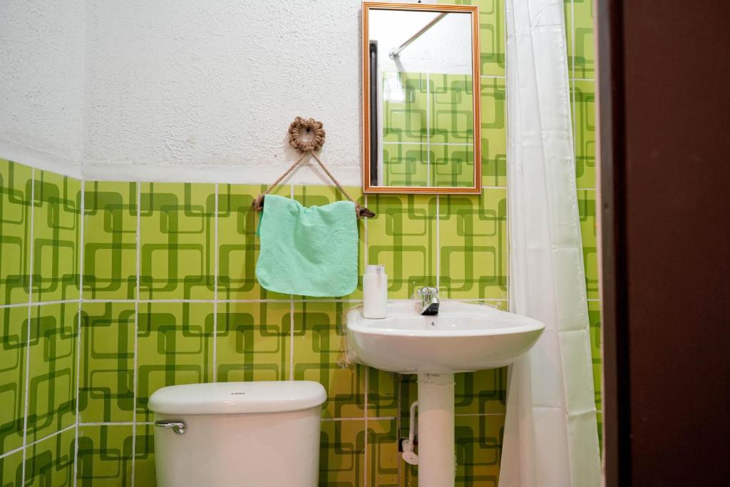 a bathroom with a sink and a toilet and a mirror at 4 Elementos Hostal in San Juan La Laguna