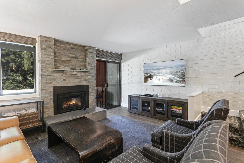 a living room with a couch and a fireplace at Stylish and Modern Park Ave Condo, Swimming Pool, 5 minutes to Main in Park City