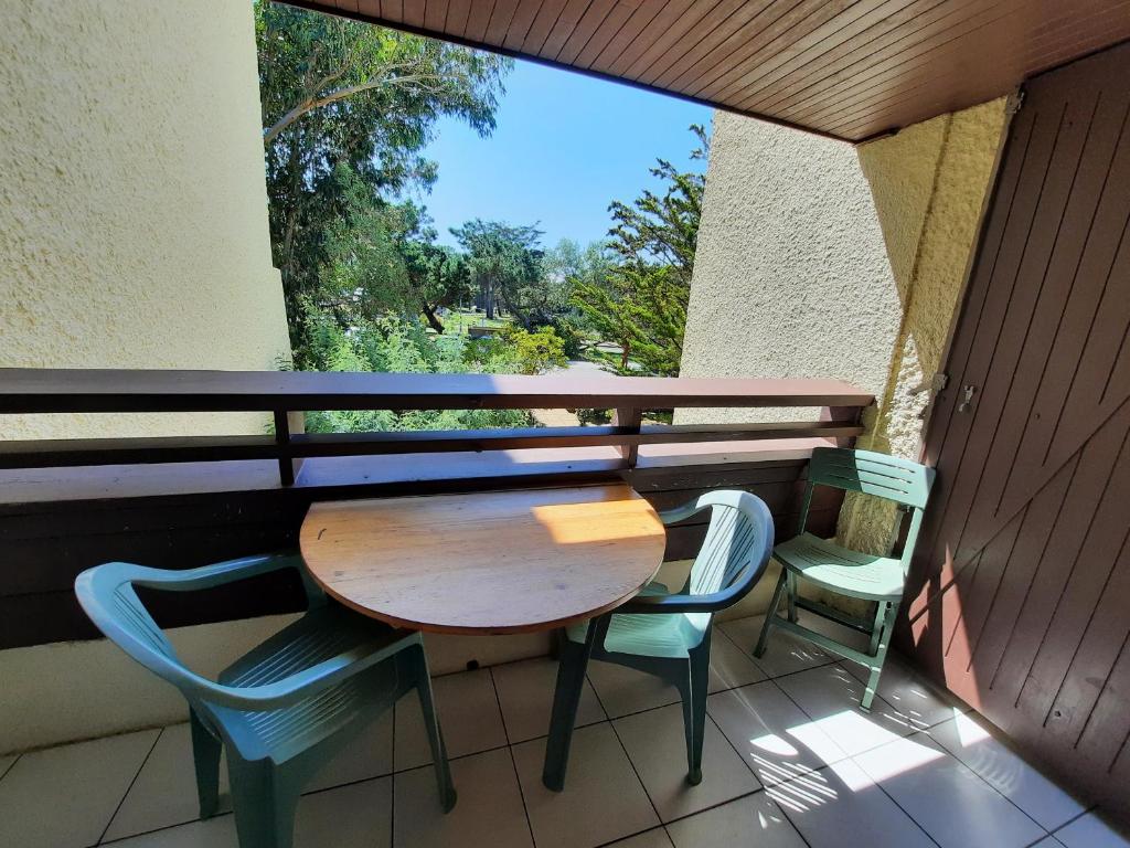 stół i krzesła na balkonie z oknem w obiekcie Appartement Lumineux à Seignosse, Proche Plage, Commerces et Activités, Parking, Wifi et Balcon - FR-1-239-813 w mieście Seignosse