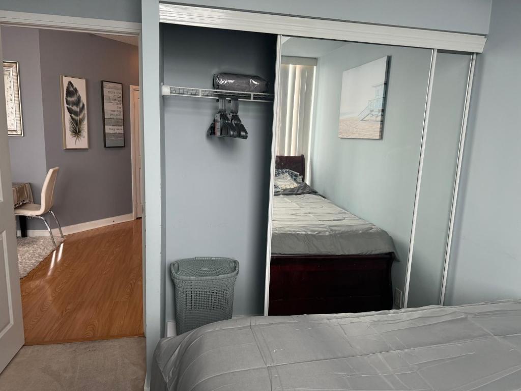 1 dormitorio con cama y armario con espejo en Lovely 1 bedroom Condo Downtown Mississauga Square One, en Mississauga