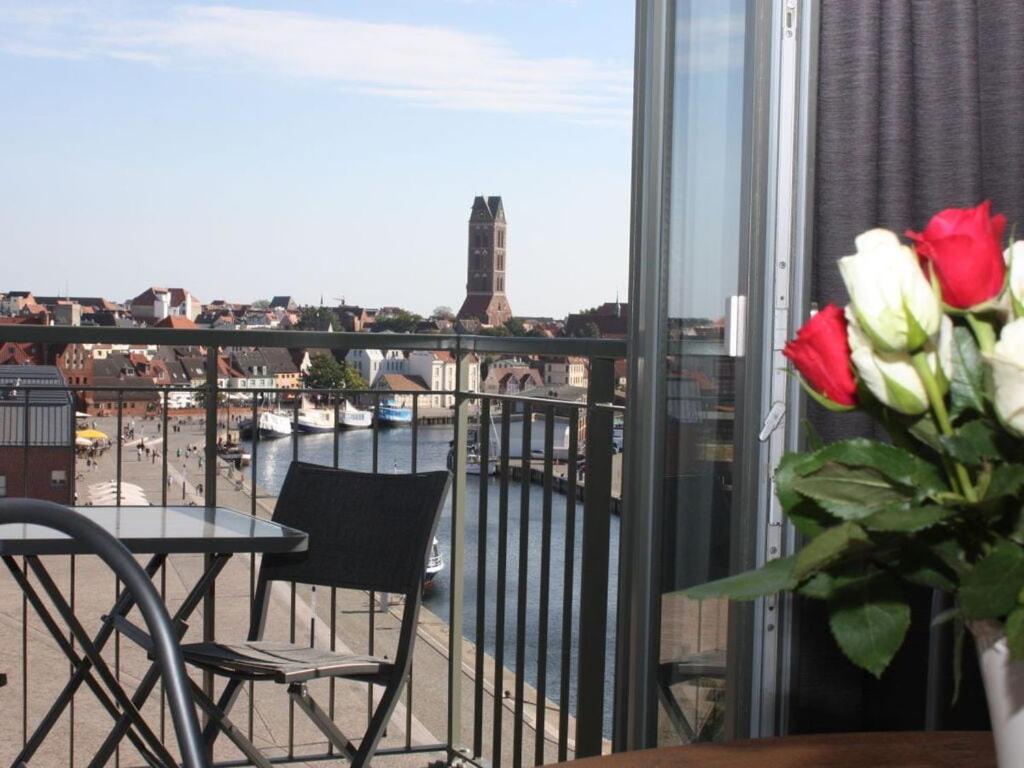 a balcony with a table and chairs and a view of the city at Old town view in the Ohlerich warehouse in Wismar