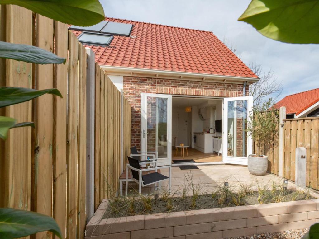uma casa com uma cerca de madeira e um pátio em Enjoy at "t Kusthuys em Zoutelande
