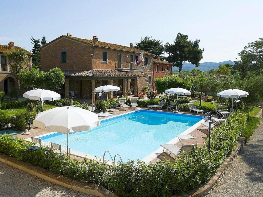 ein großer Pool mit Sonnenschirmen und ein Haus in der Unterkunft Property in Bolgheri LI in Bolgheri