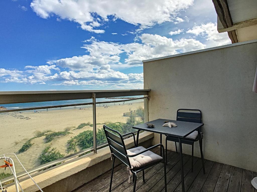 une table et des chaises sur un balcon avec vue sur la plage dans l'établissement Studio cabine moderne avec garage pour 4 personnes, vue mer - FR-1-715-15, à Mauguio