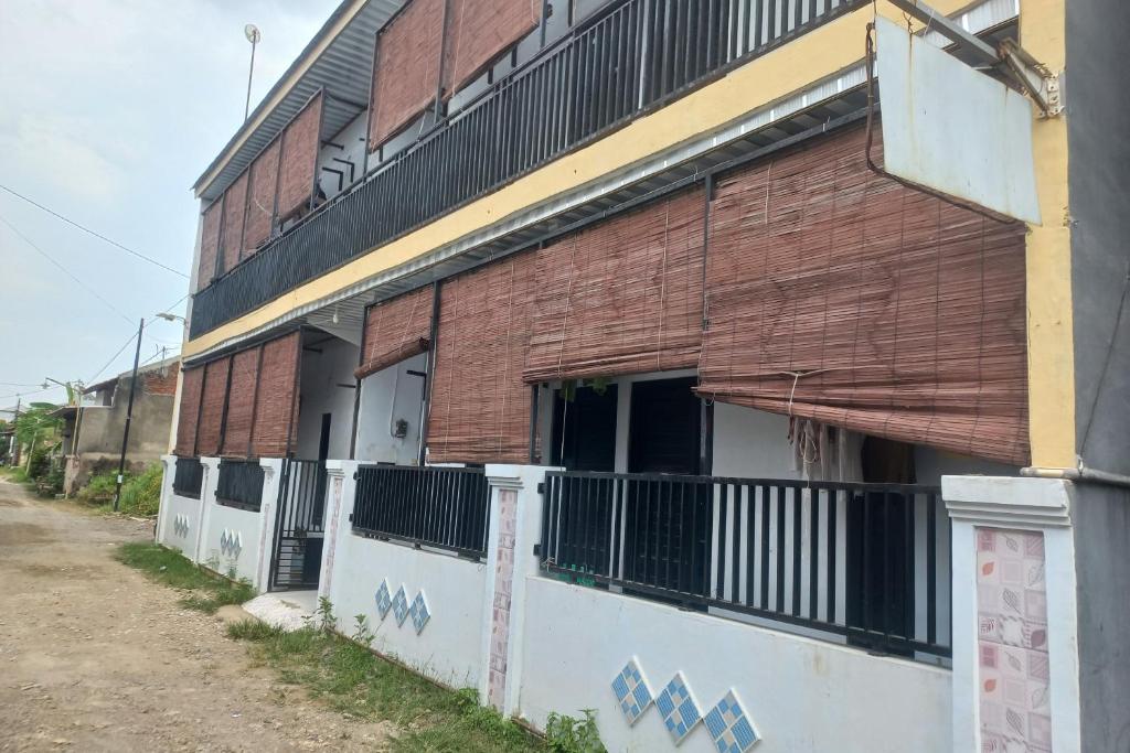 un edificio in mattoni con una porta aperta su una strada di SPOT ON 93886 Kost Zalfa Amalia Syariah a Tegal