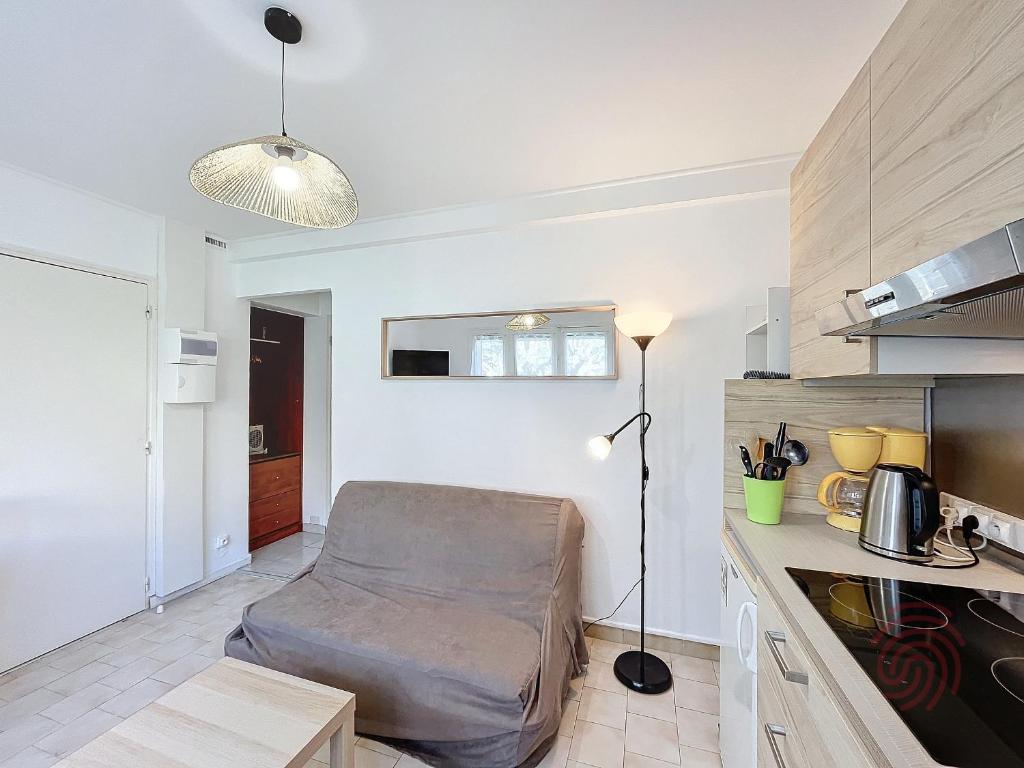 un salon avec un canapé dans une cuisine dans l'établissement Charmant T2 avec terrasse Sud, parking, WiFi, animaux acceptés - proche thermes et centre Lamalou - FR-1-451-192, à Lamalou-les-Bains