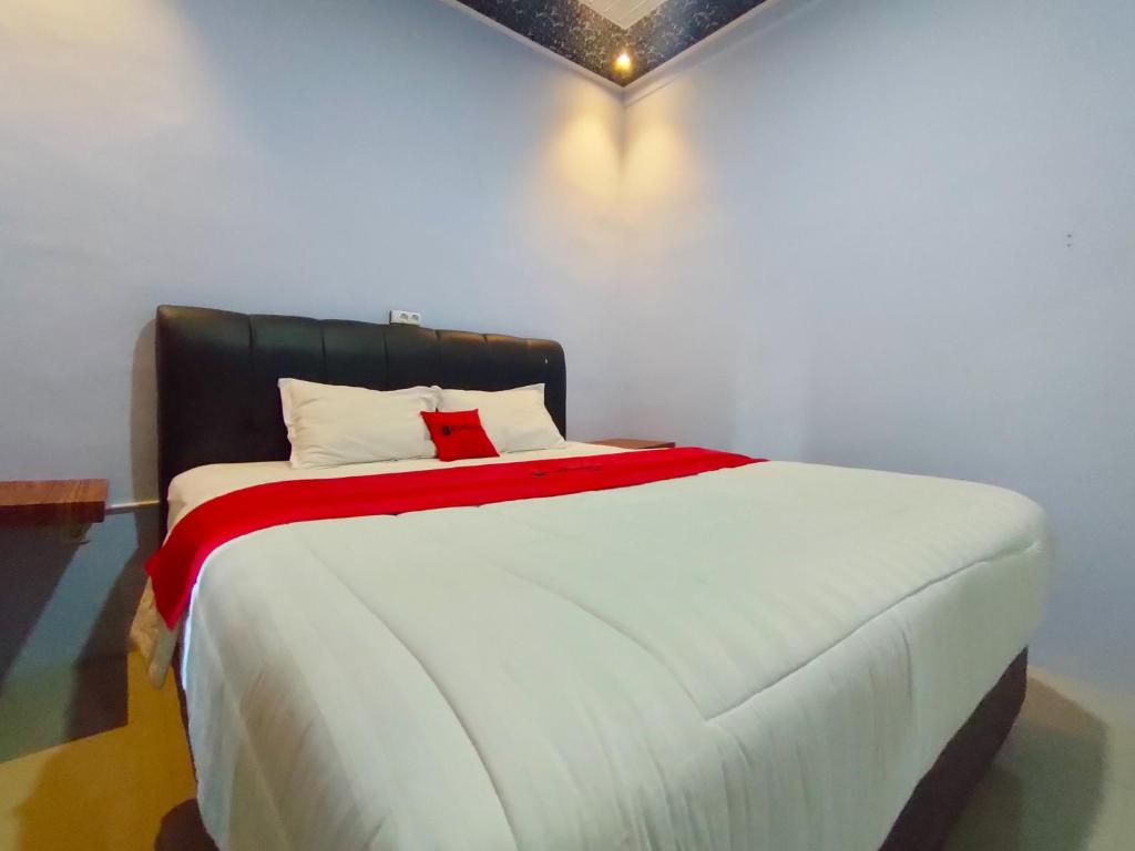 Wates的住宿－RedDoorz Syariah Near Stasiun Wates，卧室配有一张大白色床和红色毯子