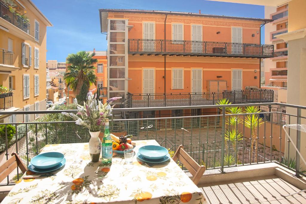 - une table sur un balcon avec vue sur un bâtiment dans l'établissement Royale Sejour - Happy Rentals, à Menton