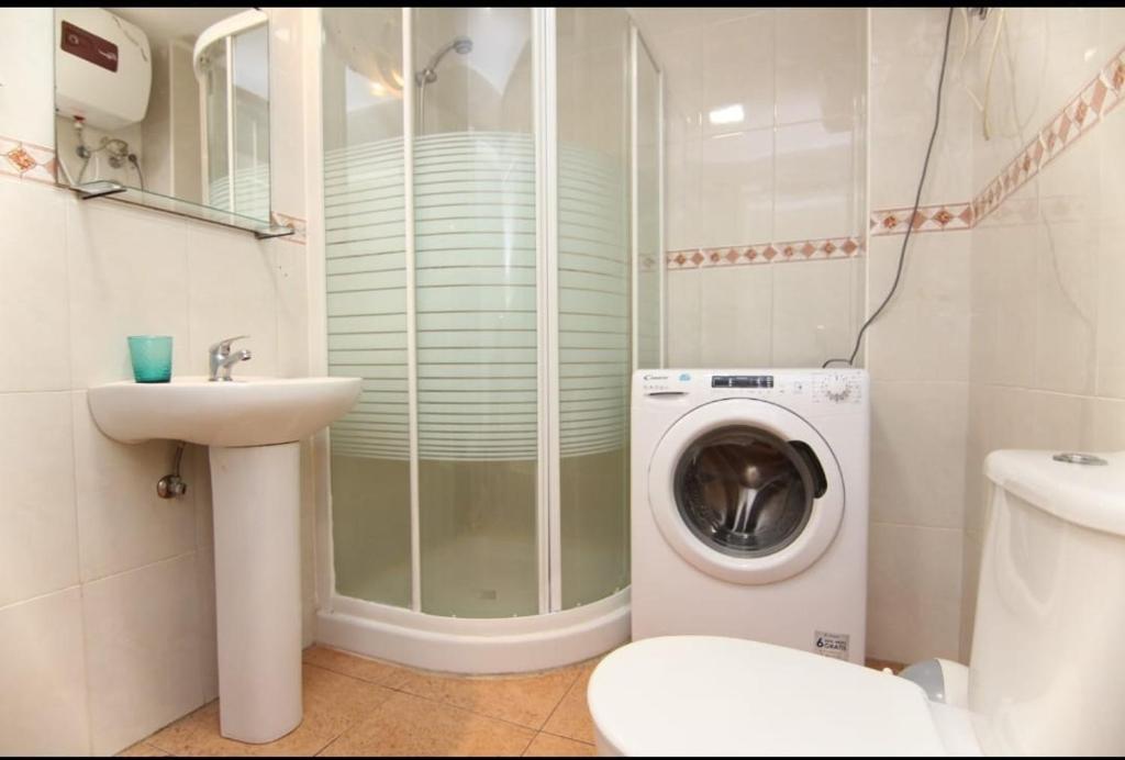 een badkamer met een wasmachine en een wastafel bij Santa Parascheva de Loma Estrella in Mogán