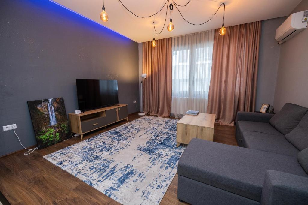 een woonkamer met een bank en een tv bij Modern Bosnian home in Sarajevo