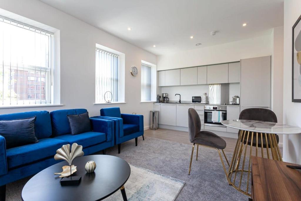 a living room with a blue couch and a table at Fantastic 1 Bedroom Apartment in Bolton in Bolton