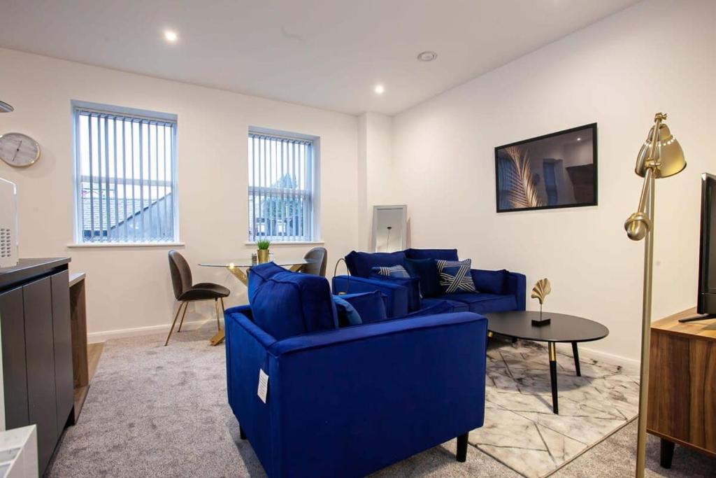 a living room with a blue couch and a table at Lovely Open Plan 1 Bedroom Apartment in Bolton in Bolton