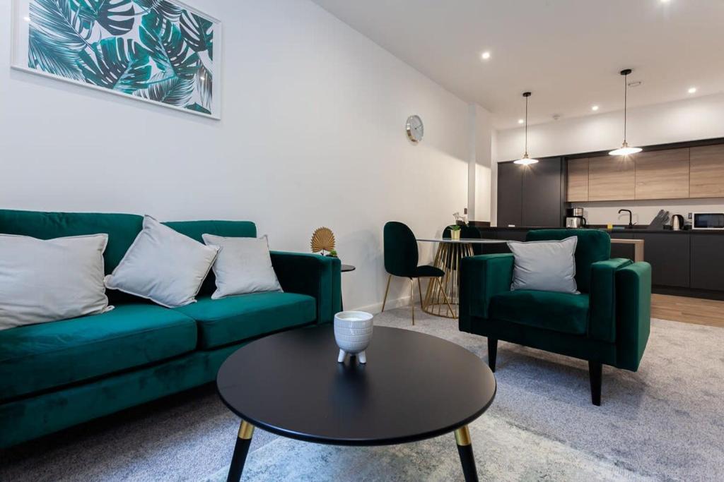 een woonkamer met een groene bank en een tafel bij Fantastic 1 bedroom apartment in Bolton in Bolton
