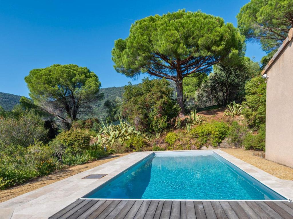 uma piscina no quintal de uma casa com árvores em Maison Le Lavandou, 5 pièces, 7 personnes - FR-1-677-45 em Le Lavandou