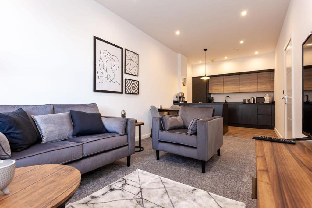 uma sala de estar com um sofá e cadeiras e uma cozinha em Modern 1 Bedroom Apartment in Bolton em Bolton