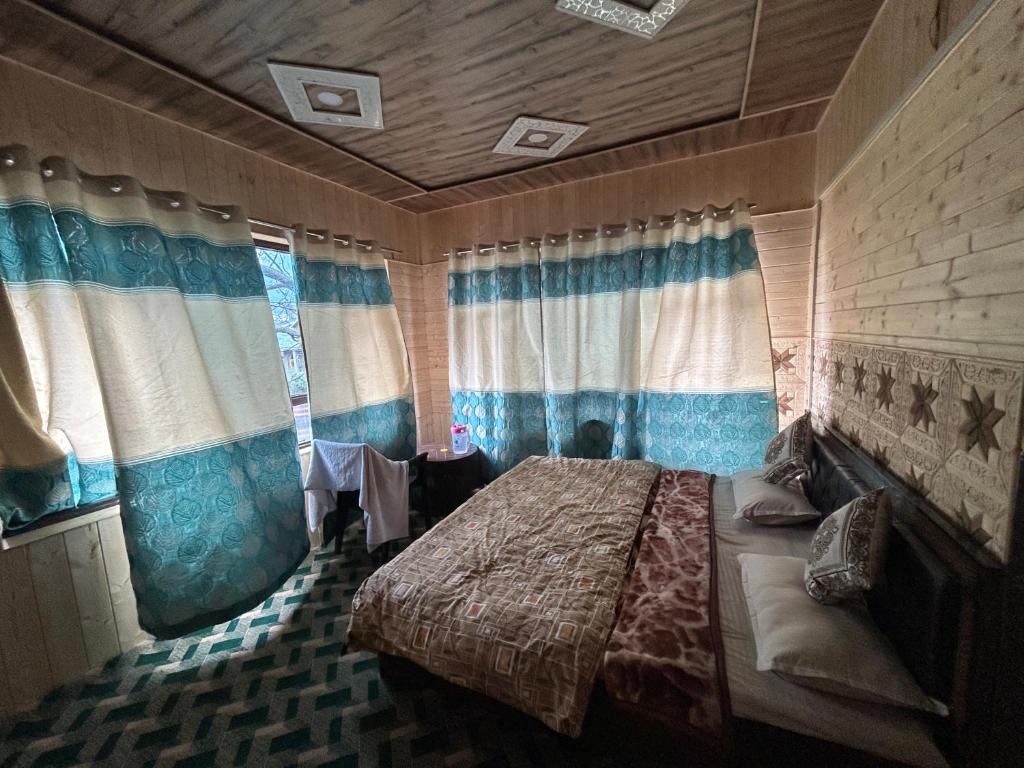 ein Schlafzimmer mit einem Bett in einem Zimmer mit Fenstern in der Unterkunft Forest inn in Pahalgām