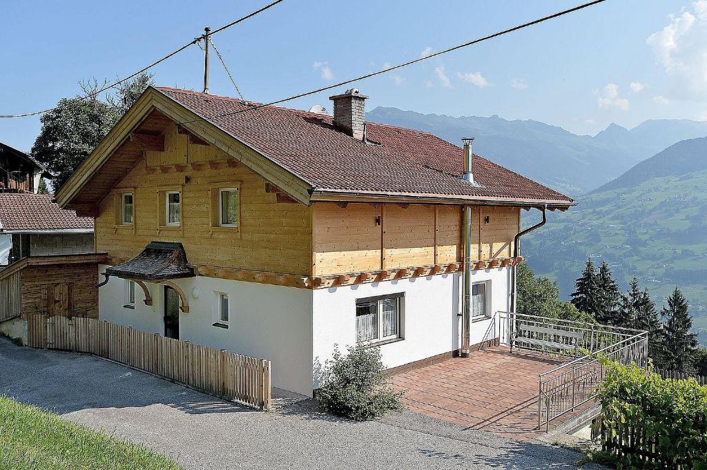 ein Haus mit einem Holzdach und einer Holzterrasse in der Unterkunft Bergchalet Emberg in Aschau