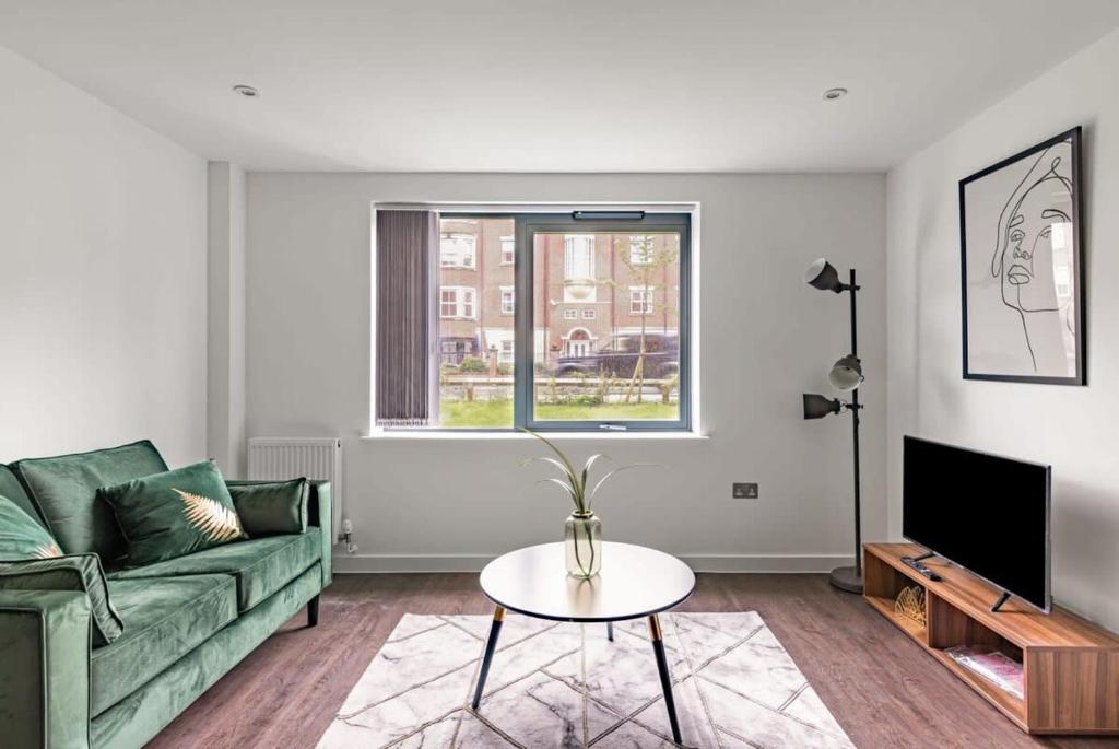 uma sala de estar com um sofá verde e uma mesa em Stunning Modern 2 Bedroom Apartment in York em York