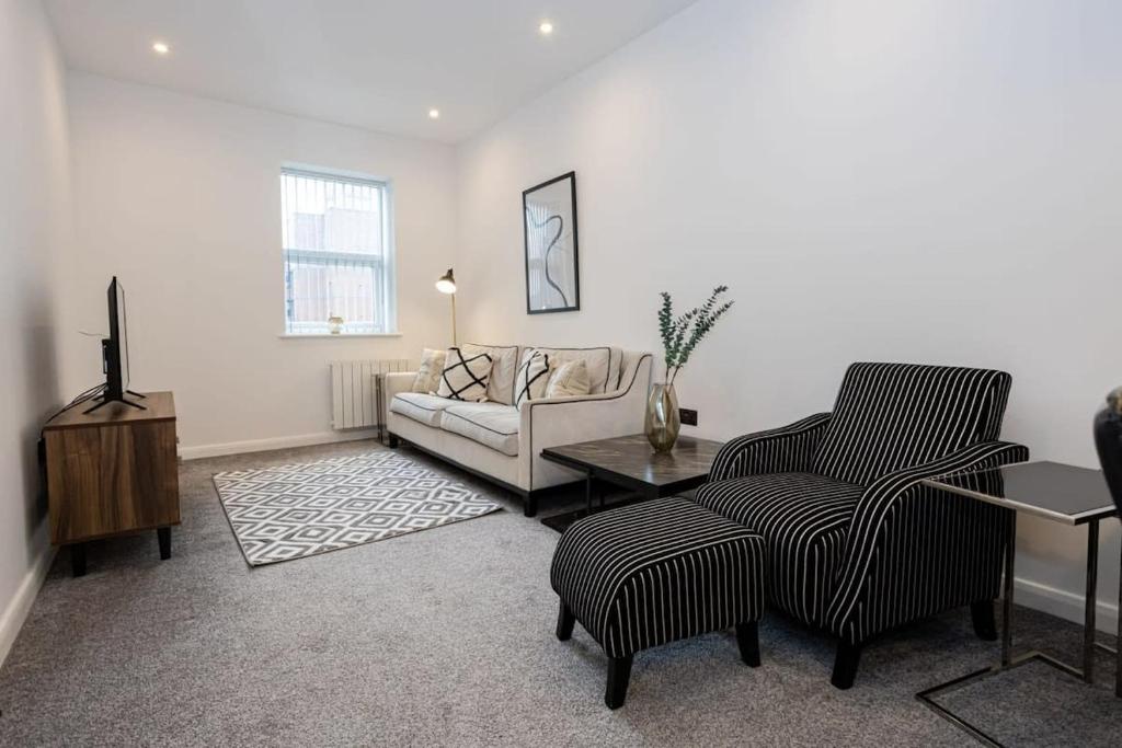 a living room with a couch and a table at Contemporary Bolton Apartment in Central Location in Bolton