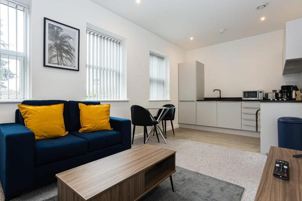 sala de estar con sofá azul y cocina en Modern 1BR Bolton Apartment in Central Location, en Bolton