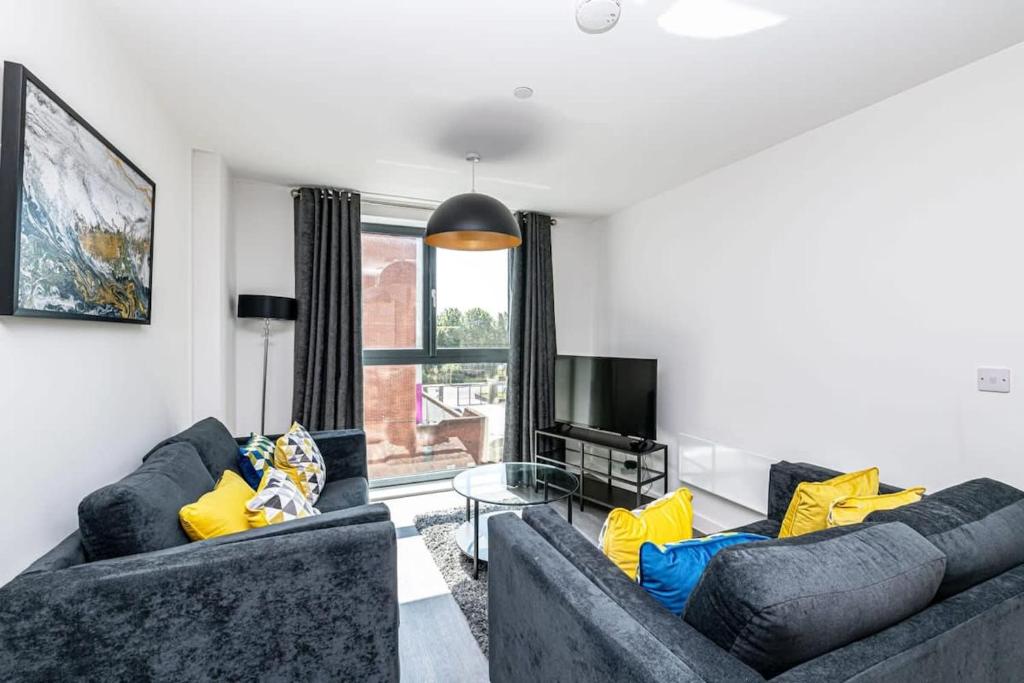 a living room with two couches and a television at Stylish 2 Bedroom Apartment by Old Trafford in Manchester