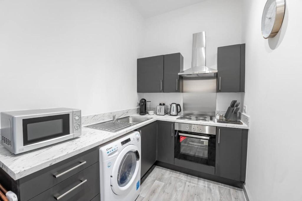 a kitchen with a microwave oven and a washer at Budget 1 Bedroom Apartment in Dudley in Brierley Hill