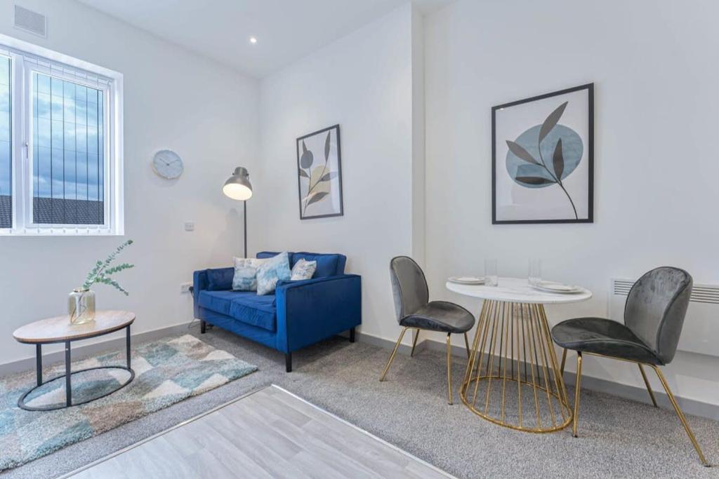 a living room with a blue couch and two chairs at Contemporary 1 Bedroom Apartment in Dudley in Brierley Hill