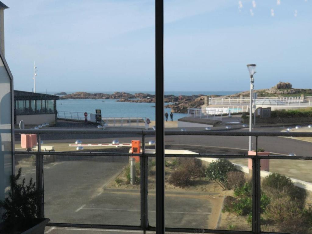 - une vue sur un parking avec une masse d'eau dans l'établissement Appartement à Trégastel - Plage Coz-Pors, WIFI, parking, animaux admis - FR-1-368-418, à Trégastel
