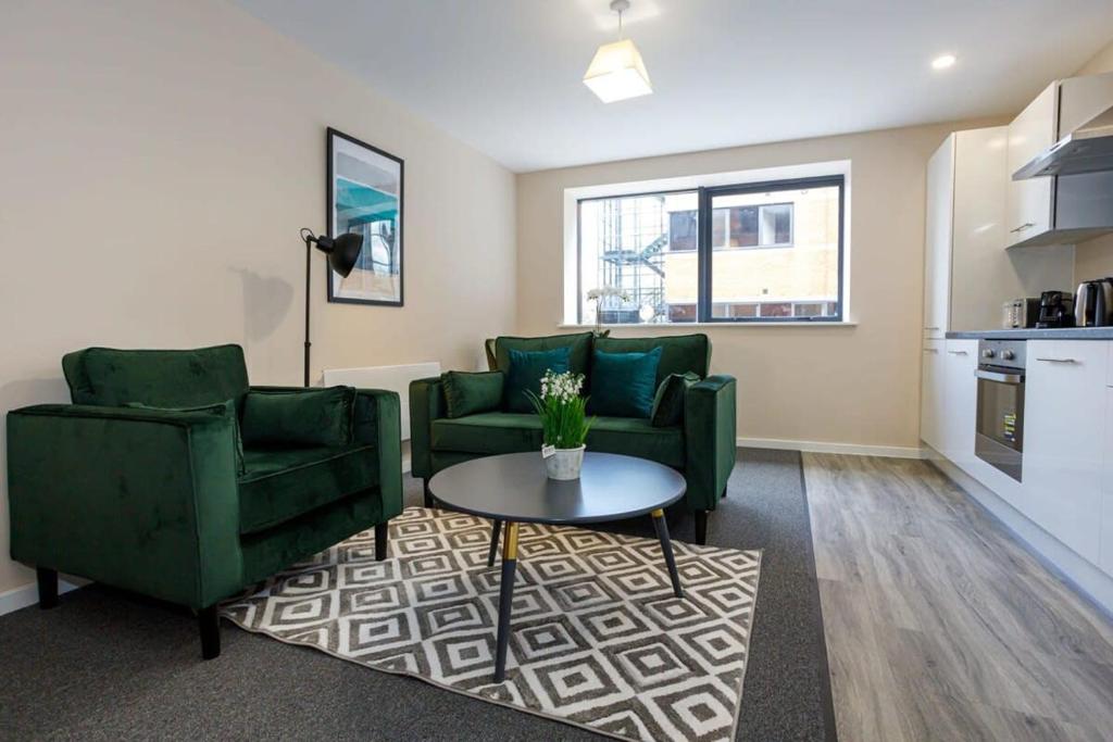 - un salon avec deux chaises vertes et une table dans l'établissement Modern 1 Bedroom Apartment, Manchester, à Manchester