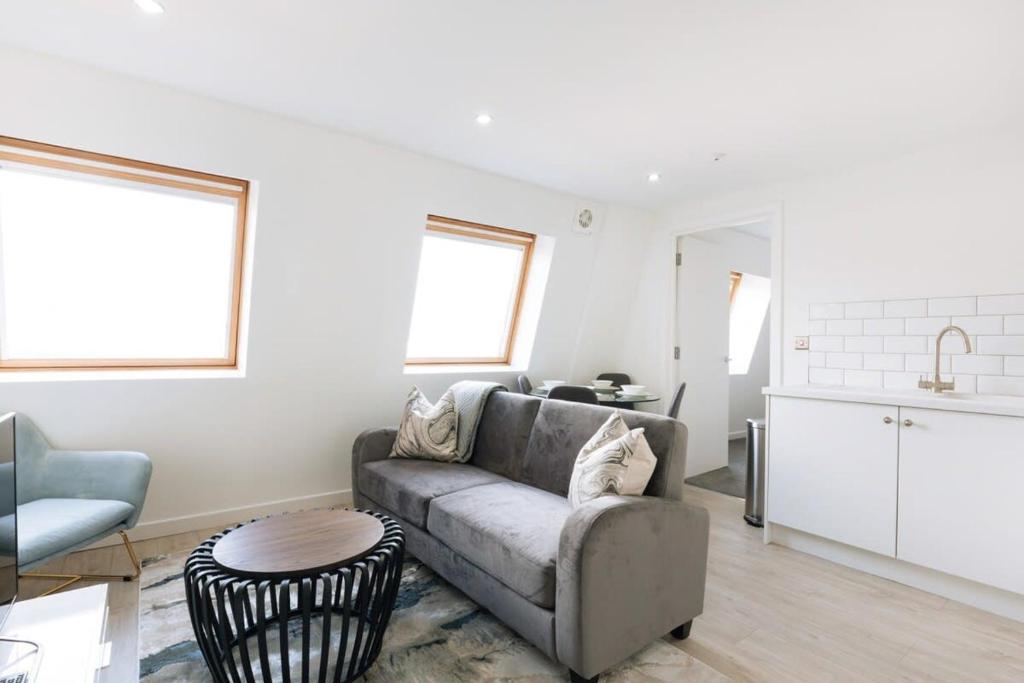 a living room with a couch and a kitchen at Modern 1BR Top Floor Apartment in Ipswich in Ipswich