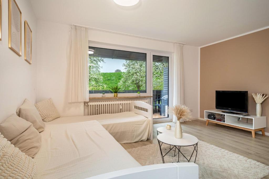 a white living room with a couch and a window at Ferienwohnung Achraintal 3 in Lindau