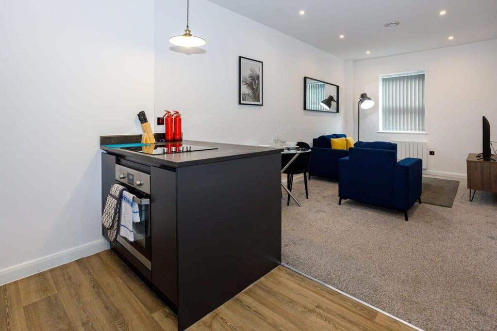 a kitchen with a counter and a living room at Contemporary 1 Bed Apartment Central Bolton in Bolton