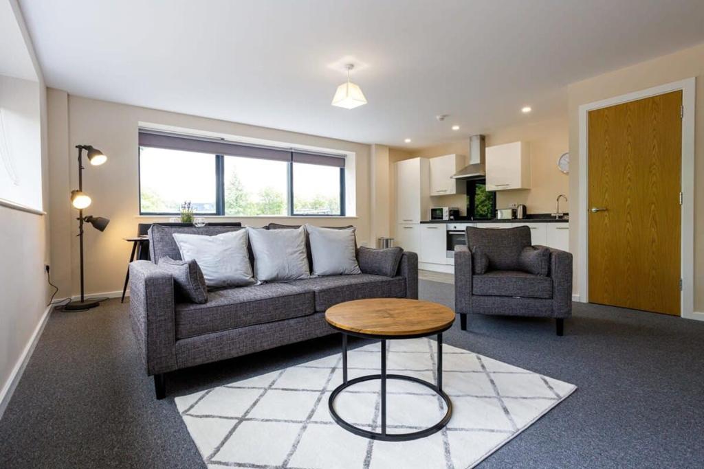 a living room with a couch and a table at Modern 2 Bedroom Apartment Manchester in Manchester