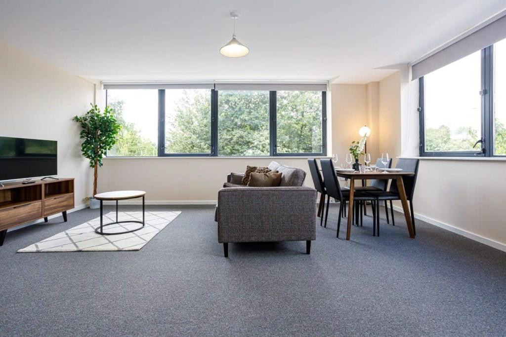 ein Wohnzimmer mit einem Sofa und einem Tisch in der Unterkunft Stylish and Bright 2 Bedroom Apartment Manchester in Manchester