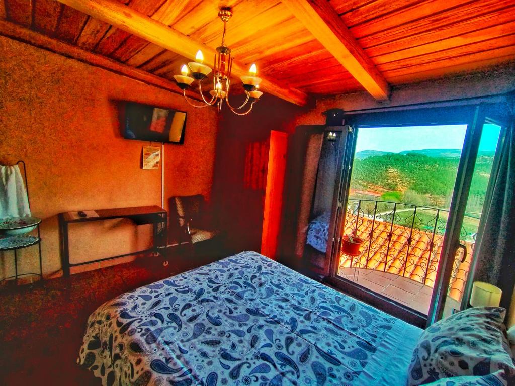 a bedroom with a bed and a window with a view at Casa Rural Garrido in Ademuz
