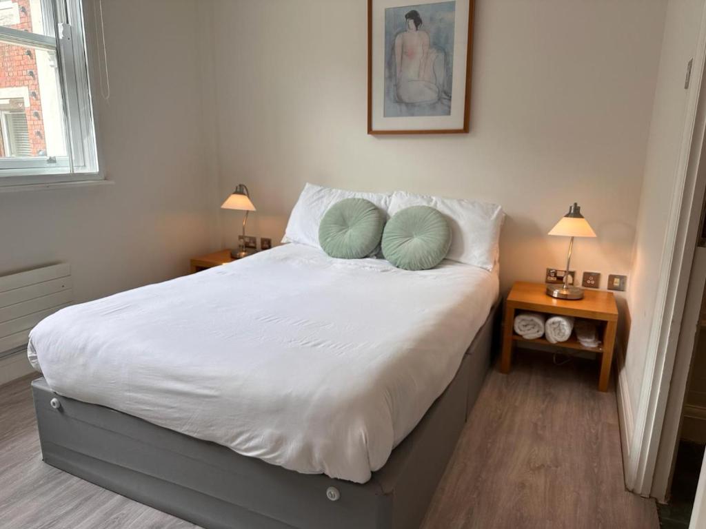 een slaapkamer met een bed met 2 kussens erop bij Gallery Apartments in Londen