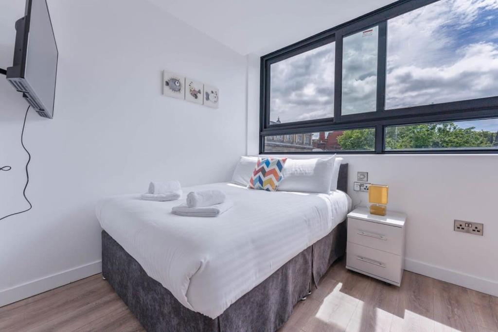 a bedroom with a large bed with a large window at Lovely Studio Apartment in Central Sheffield in Sheffield