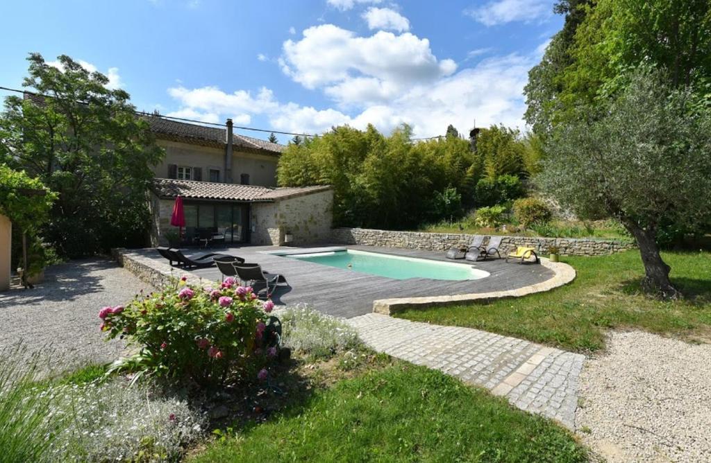 a backyard with a swimming pool and a house at Le Relais du Vivarais in Viviers