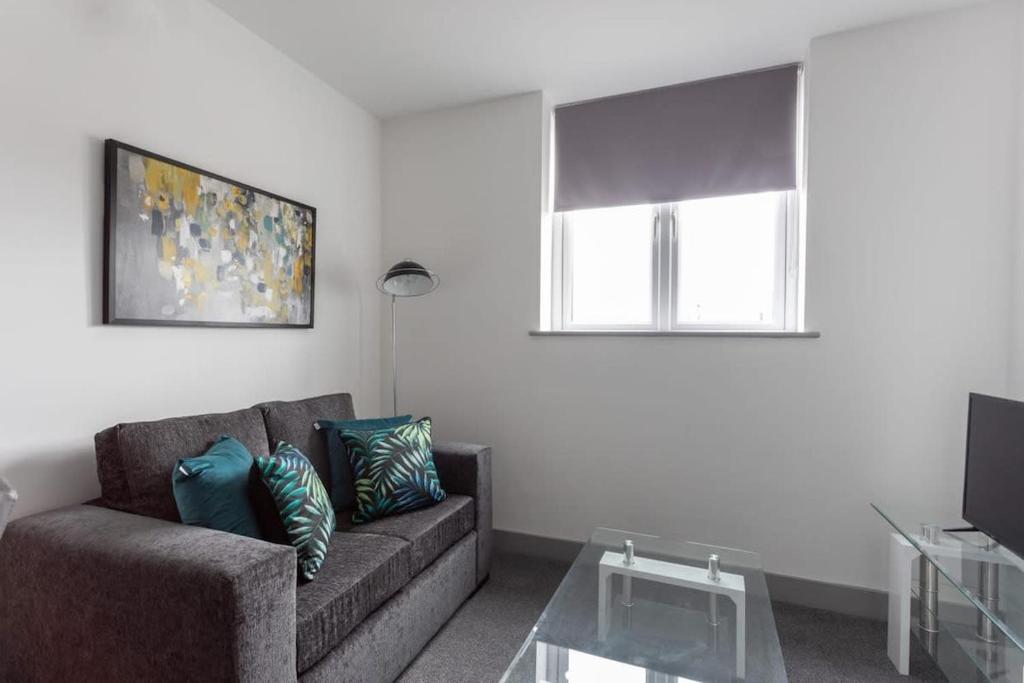 ein Wohnzimmer mit einem Sofa und einem Fenster in der Unterkunft Cosy 1 Bed Apartment in Leeds in Leeds